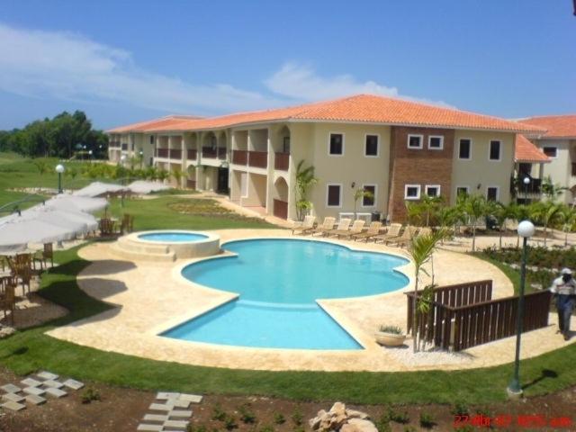 a swimming pool in front of a building at Green Paradise in Juan Dolio