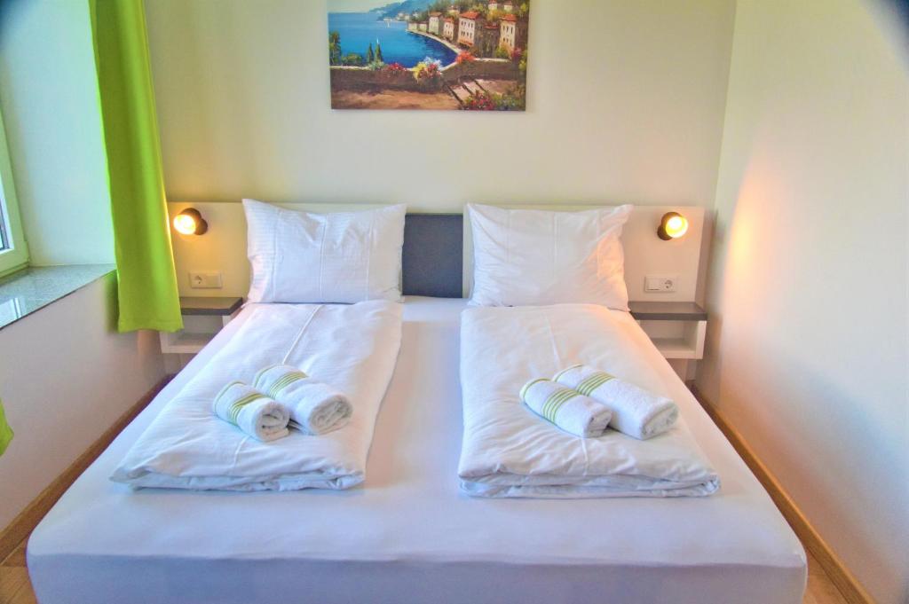 a bedroom with two beds with towels on them at bestprice Hotel Aachen Hauptbahnhof in Aachen