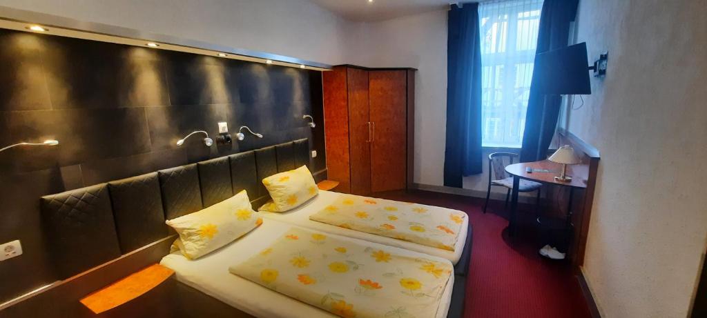 um quarto de hotel com duas camas e uma janela em Hotel Corveyer Hof em Höxter