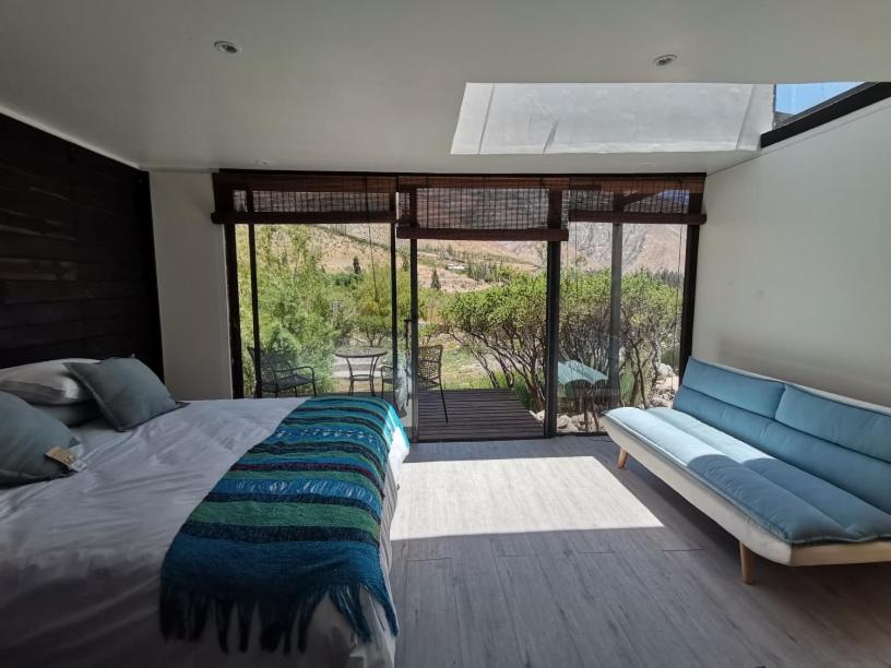 sypialnia z dużym łóżkiem i kanapą w obiekcie Reset Elqui w mieście Alcoguaz