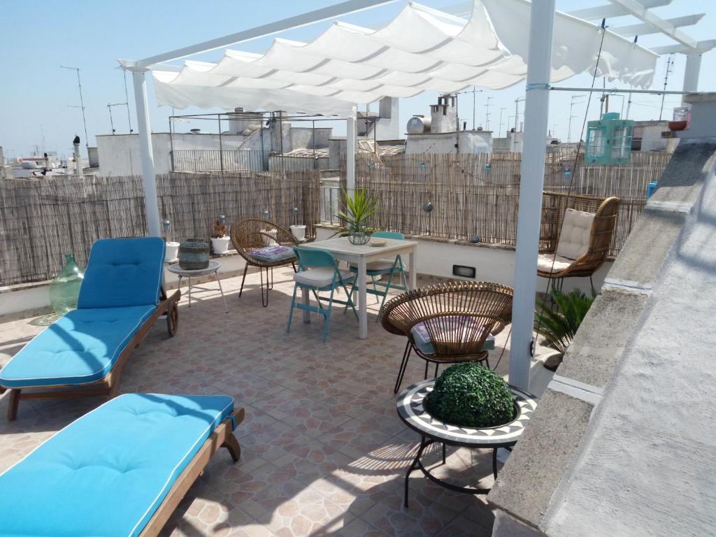 patio con tavolo, sedie e ombrellone di One bedroom house with sea view furnished terrace and wifi at Ostuni 5 km away from the beach a Ostuni