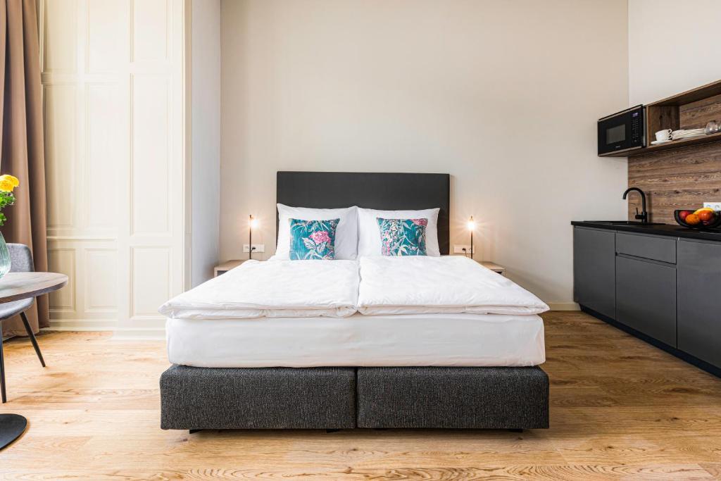 a bedroom with a large white bed with blue pillows at Franz BY ZEITRAUM in Prague