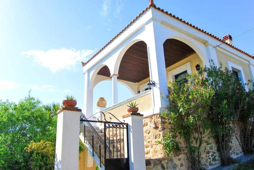 a villa with a gate in front of a house at 5 bedrooms villa at Limnos 250 m away from the beach with sea view enclosed garden and wifi in Lemnos