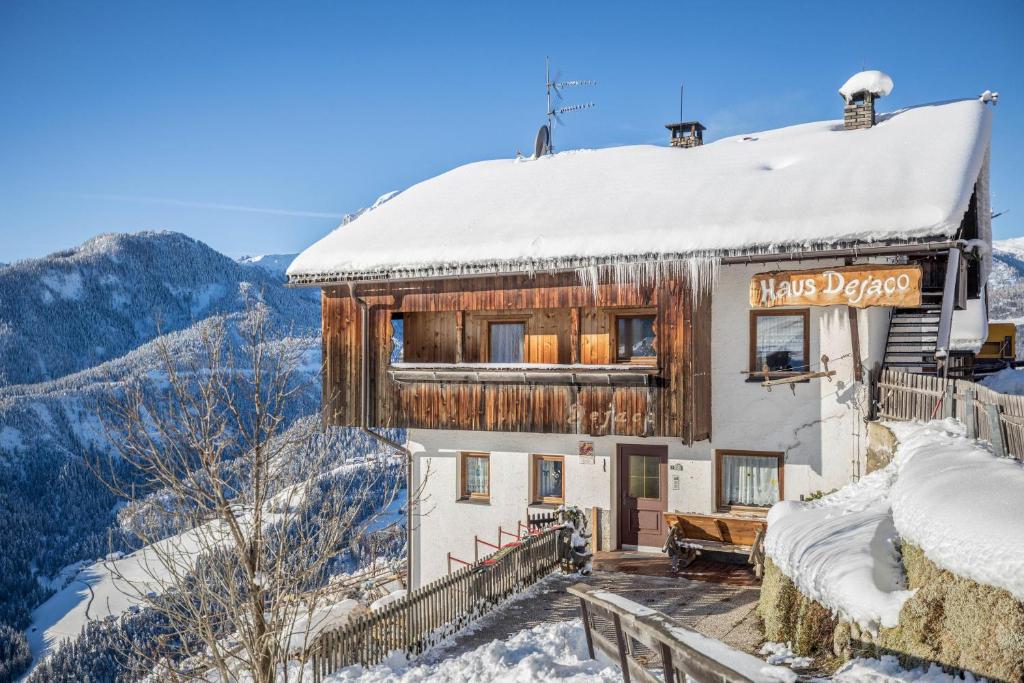 a house with a snow covered roof on a mountain at Appartamento primo piano in San Martino in Badia