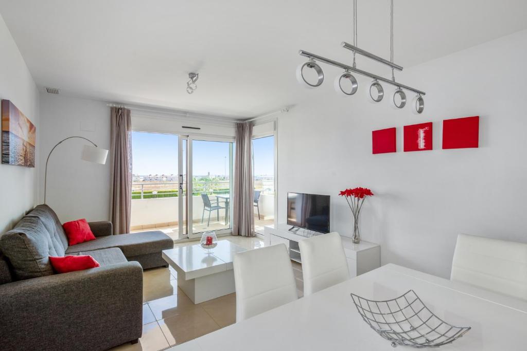 プレヤス・デ・オリフエラにある3 bedrooms apartement with sea view shared pool and enclosed garden at Orihuela 3 km away from the beachのリビングルーム(ソファ、テーブル付)