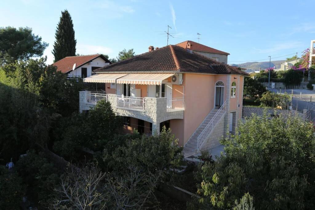 a large house with a balcony and stairs on it at Apartment Bareta in Trogir