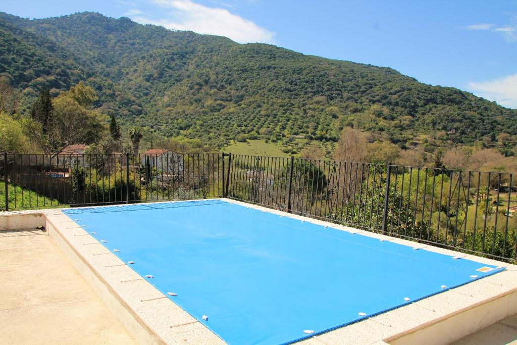 a blue swimming pool with a mountain in the background at Charming Villa in Benamahoma + Pool in Benamahoma