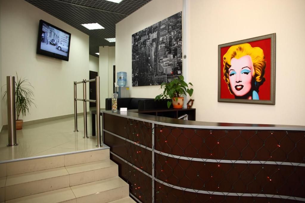 una sala de espera con una pintura de una mujer en la pared en Hotel Aksioma, en Gatchina