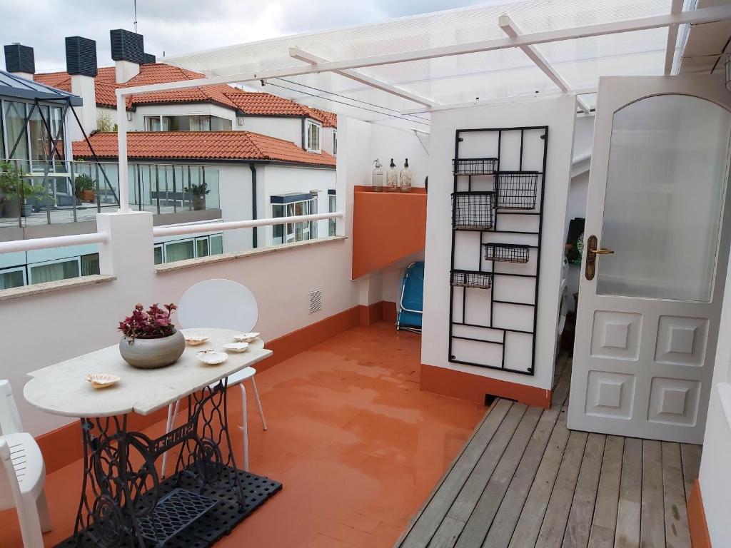 a balcony with a white door and a table on a deck at Spacious house with terrace and balcony in A Coruña in A Coruña