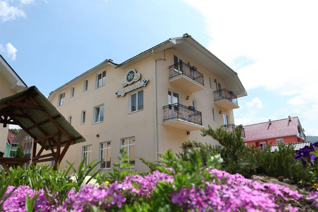 un edificio con fiori rosa di fronte di Edelweiss a Polyana