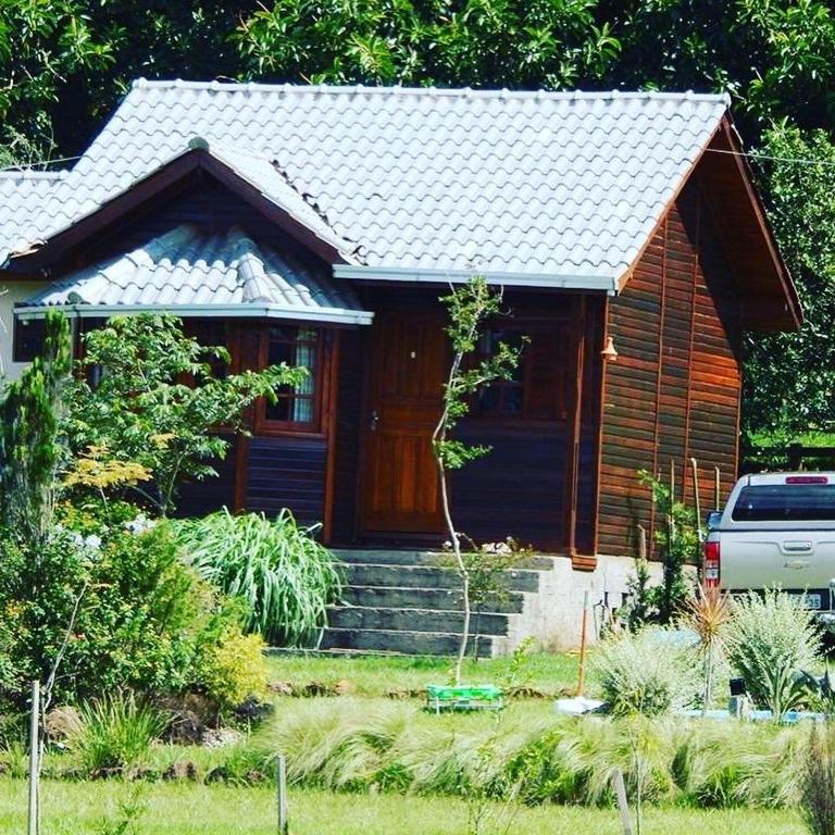 a small house with a blue door in a yard at RANCHO COSTEIRO AGROTURSIMO E BALNEARIO E PESQUEIRO in Pôrto Xavier