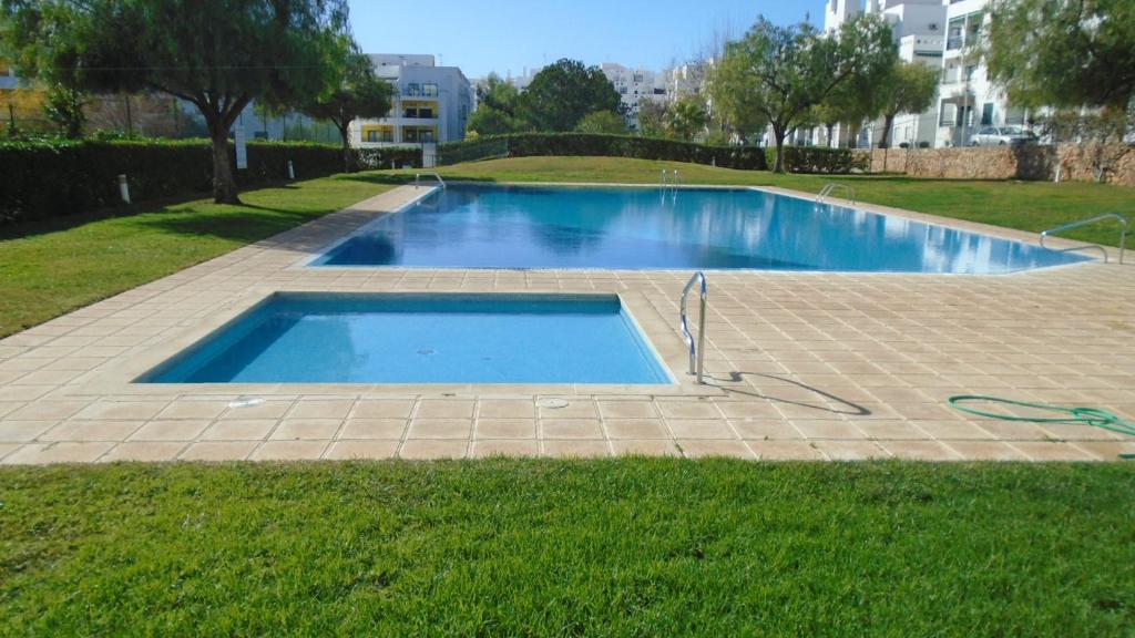 ein Swimmingpool mitten in einem Hof in der Unterkunft Spacious Apartment in Armação de Pêra with Sea View - 90 m² in Armação de Pêra