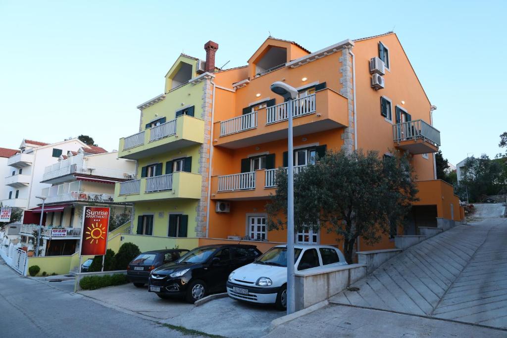 un edificio con coches estacionados frente a él en Sunrise Apartments 2, en Cavtat