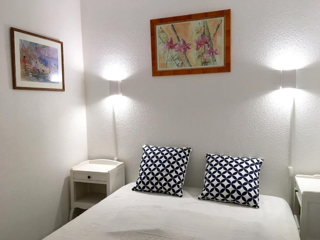 um quarto com uma cama com duas almofadas em Appartement d'une chambre a Guerande a 600 m de la plage avec vue sur la mer piscine partagee et jardin clos em Guérande