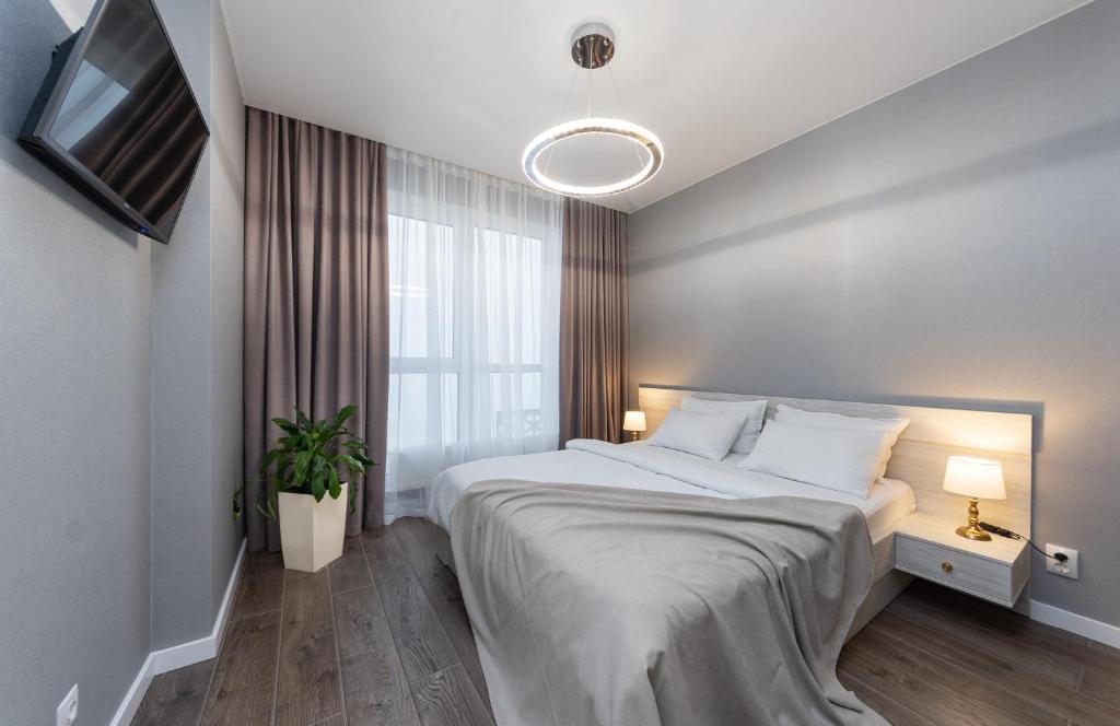 a bedroom with a large bed and a window at Люкс в ЖК Лебединый, Харьковская, Позняки in Kyiv