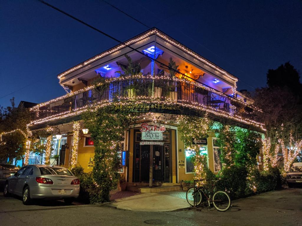 a building covered in christmas lights with a bike parked outside at Balcony Guest House in New Orleans