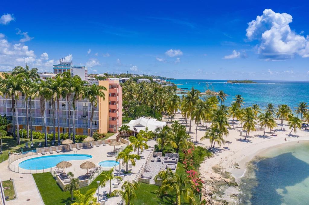 einen Luftblick auf ein Resort mit Palmen und dem Meer in der Unterkunft Zenitude Hôtel Résidences Le Salako in Le Gosier