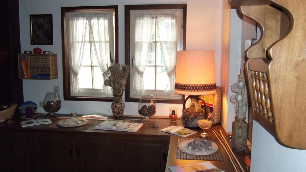 Zimmer mit einem Schreibtisch mit einer Lampe und 2 Fenstern in der Unterkunft Gasthof Stadtschänke in Großbottwar