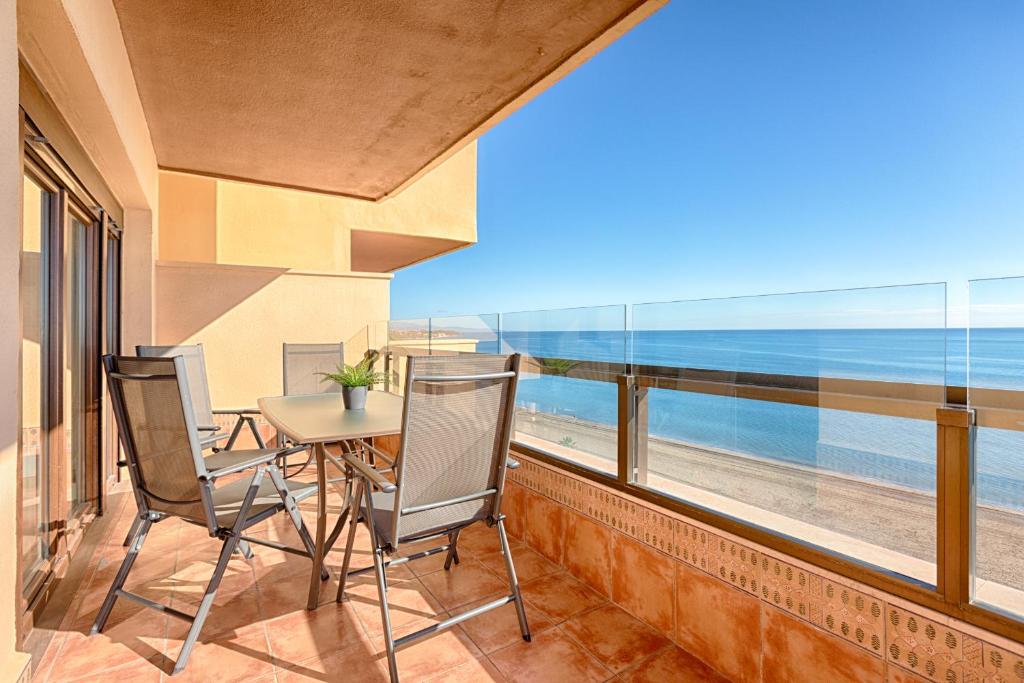 a balcony with a table and chairs and a view of the beach at Hanami Avenida de España in Estepona