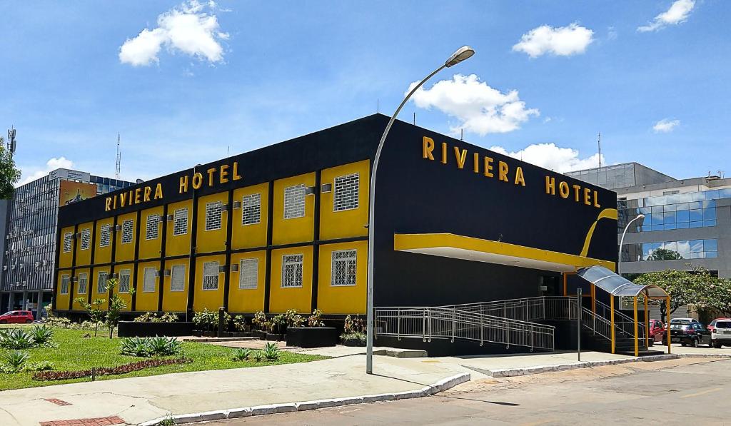 巴西利亞的住宿－里維埃拉酒店，停车场里的一个黄色和黑色的建筑