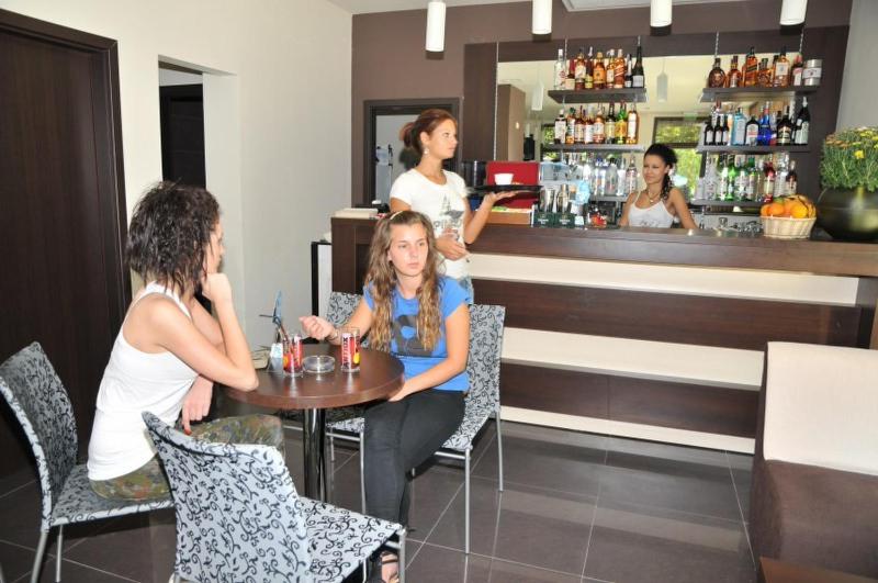 a group of people sitting at a table in a bar at Hotel Burgas Free University in Burgas
