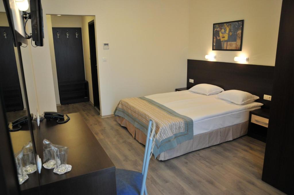 a hotel room with a bed and a desk at Hotel Burgas Free University in Burgas