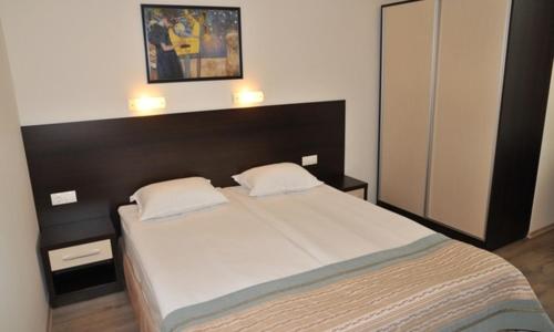 a bedroom with a large bed with two pillows at Hotel Burgas Free University in Burgas
