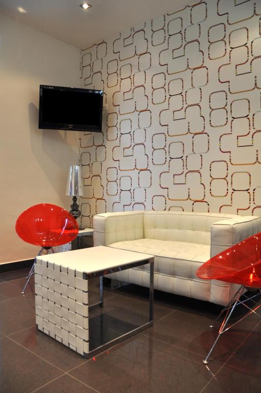 a living room with a white couch and red chairs at Hotel Burgas Free University in Burgas