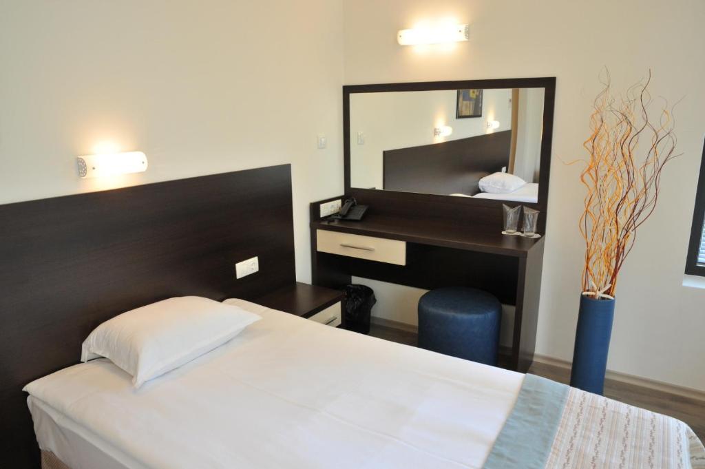 a bedroom with a bed with a mirror and a desk at Hotel Burgas Free University in Burgas