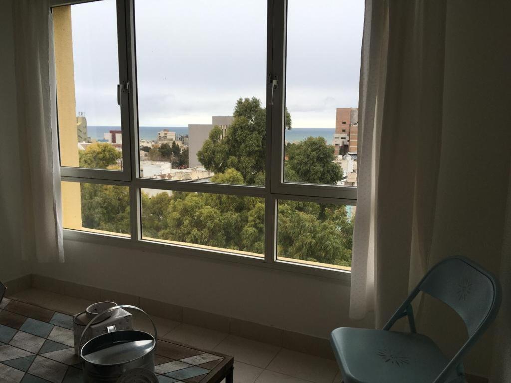 コモドーロ・リバダビアにあるCactuSの窓、椅子、テーブルが備わる客室です。