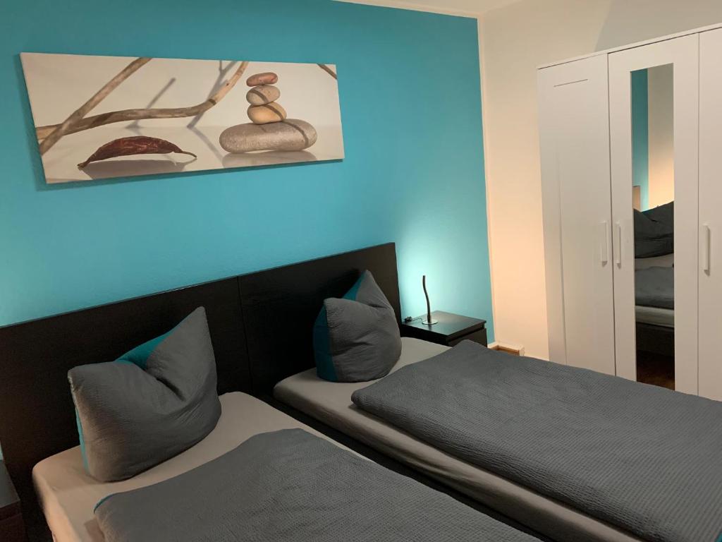 1 dormitorio con 2 camas y pared azul en Ferienwohnung Gaussblick, en Dransfeld