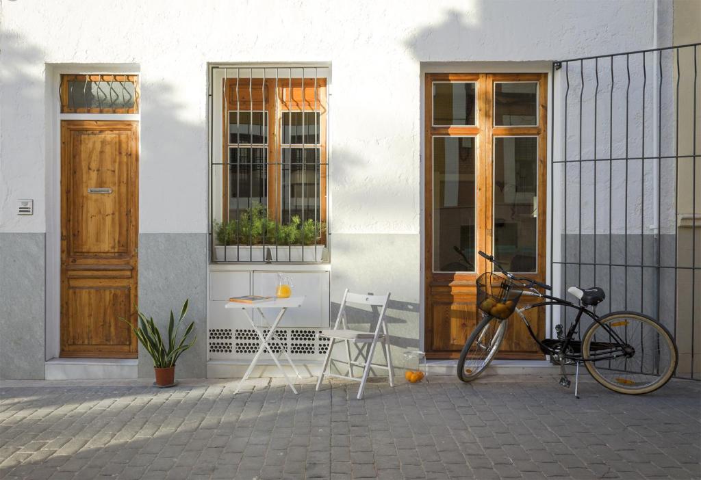 una bicicleta estacionada fuera de un edificio con una mesa y sillas en Casa Gall4, en Elche