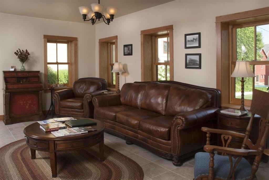 - un salon avec un canapé en cuir et une table dans l'établissement Lake Orchard Farm Retreat, à Sheboygan