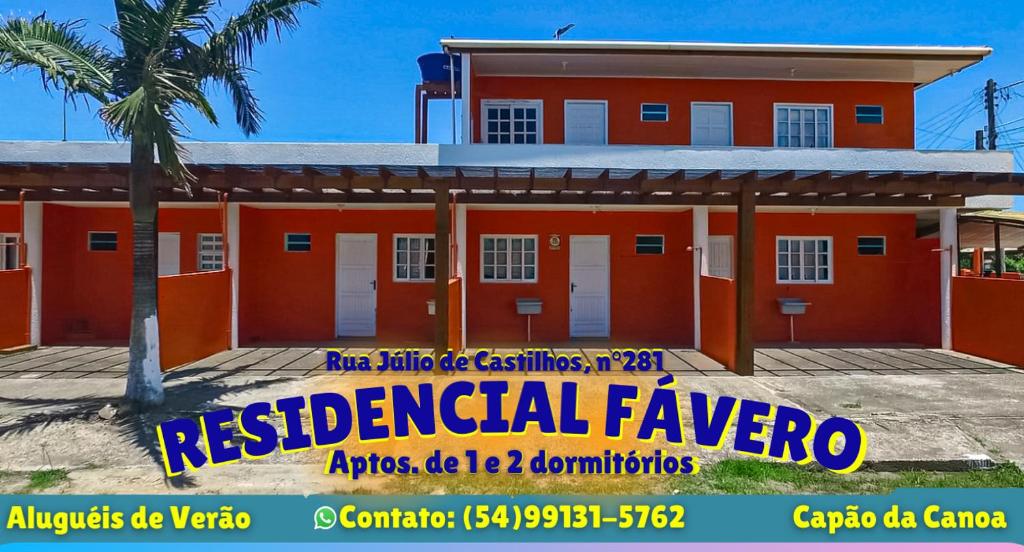 a red building with a sign in front of it at RESIDENCIAL FÁVERO in Capão da Canoa