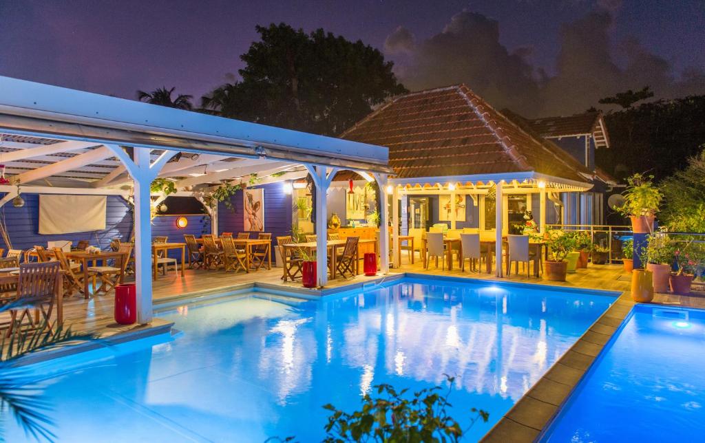 - une piscine en face d'une maison la nuit dans l'établissement Hôtel Frégate Bleue, au François