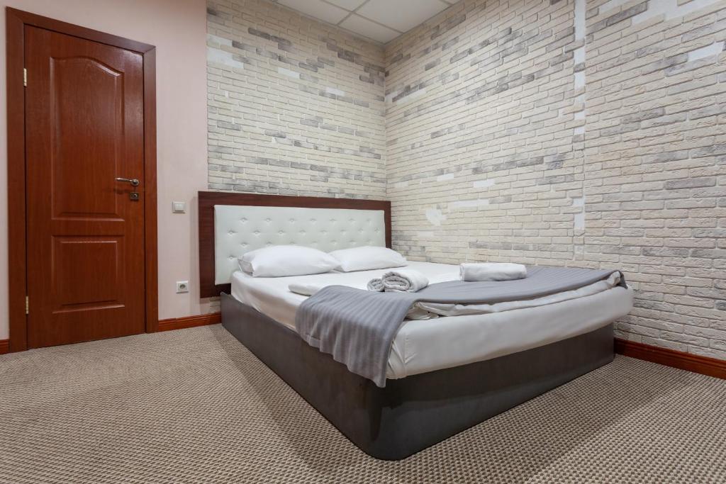 a bedroom with a large bed with a brick wall at Viven Mini-Hotel in Moscow
