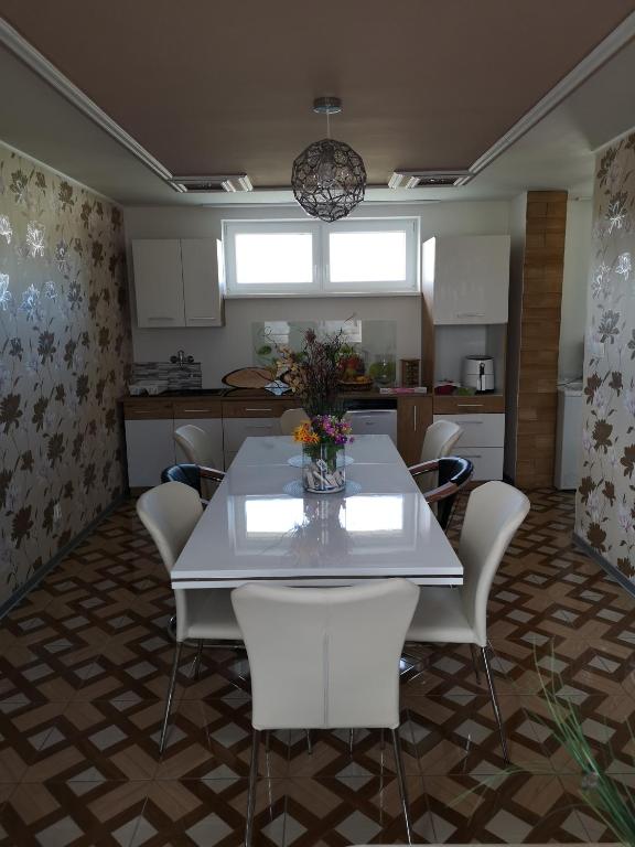 a dining room with a white table and chairs at Ubytovňa Ivona in Hroboňovo
