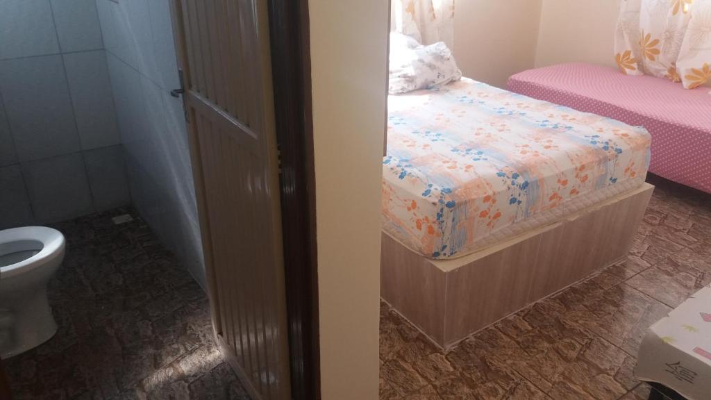 een kleine slaapkamer met een bed en een toilet bij ApartHotel Família Meireles in Luziânia