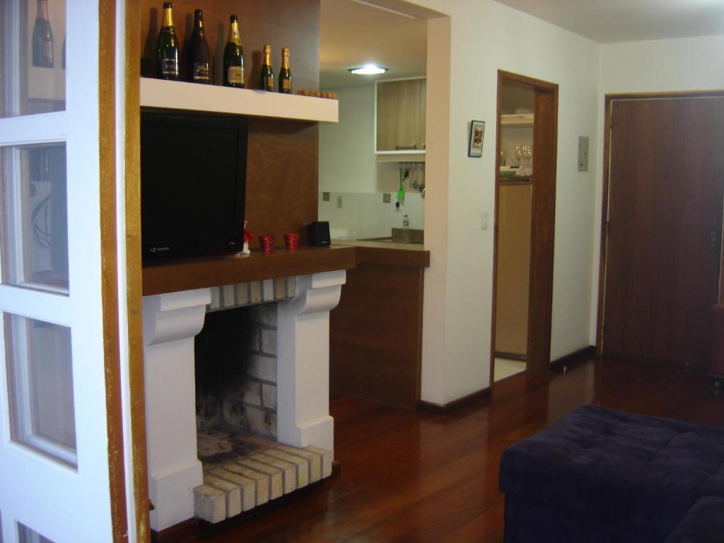 uma sala de estar com lareira e televisão em GringsApsAluguel204 em Gramado