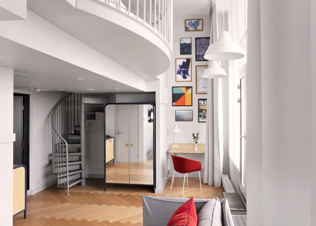 a living room with a couch and a red chair at Radisson Blu Seaside Hotel, Helsinki in Helsinki