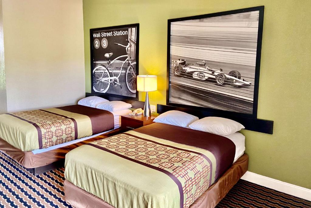 a hotel room with two beds and a picture of a car at Super 8 by Wyndham Rocky Mount I-95 EXIT 145 in Battleboro