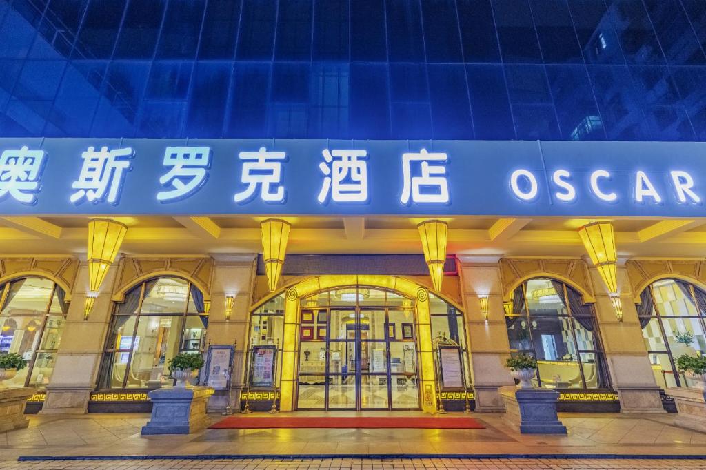 un edificio con una señal azul en la parte delantera en Haikou Jingheng Hotel - formerly the New Osrock Hotel, en Haikou