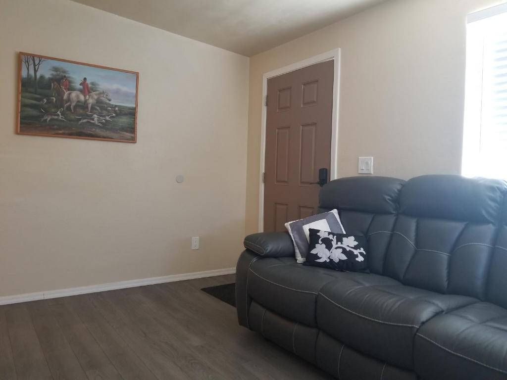 una sala de estar con un sofá azul y una pintura en Southwest Tucson Gateway, en Tucson