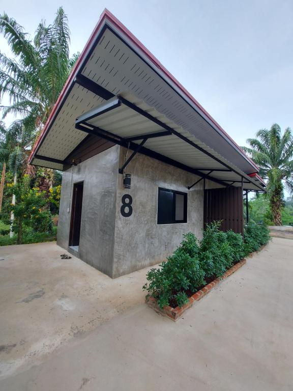 a small building with a roof with the number eight at ชาลีรีสอร์ท ชุมพร in Chumphon