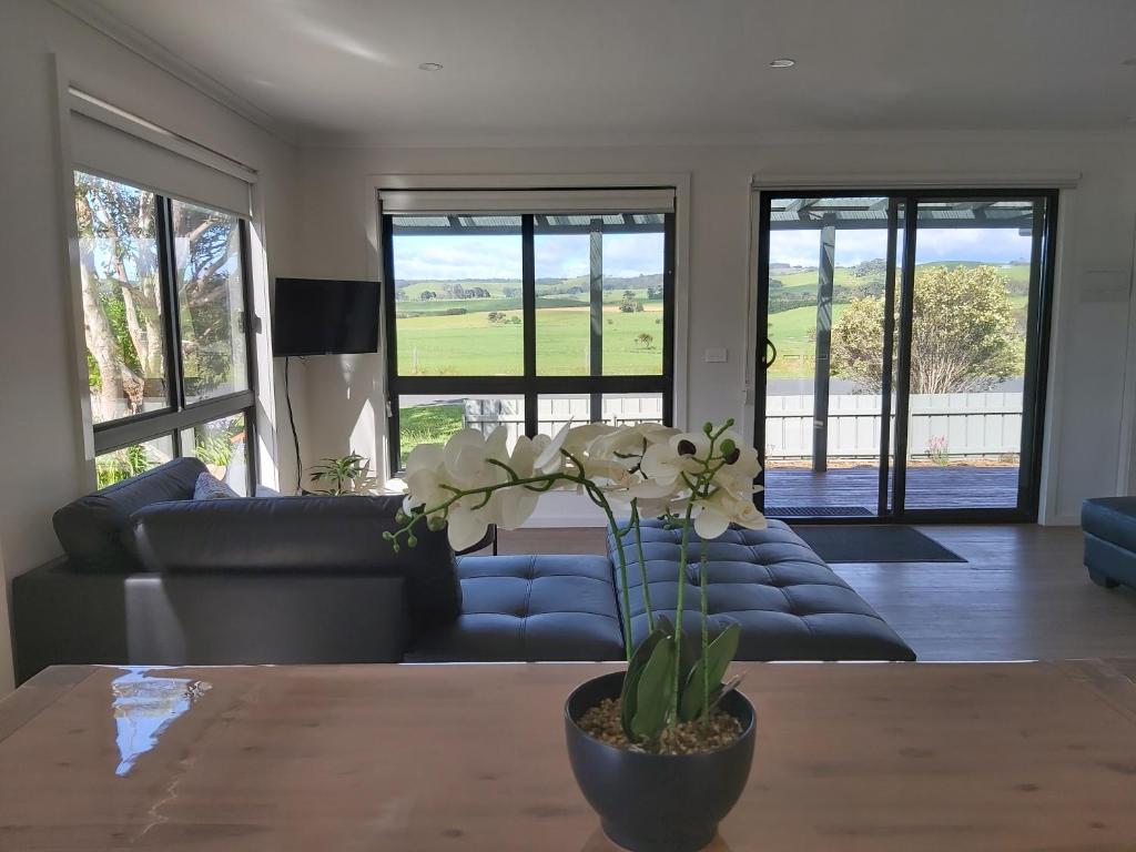 a living room with a blue couch and a table at Sunset View Villa in Apollo Bay