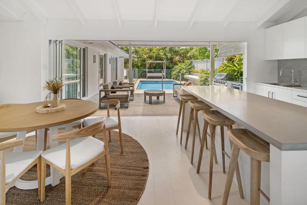 an open kitchen and dining room with a table and chairs at Alkira in Lennox Head