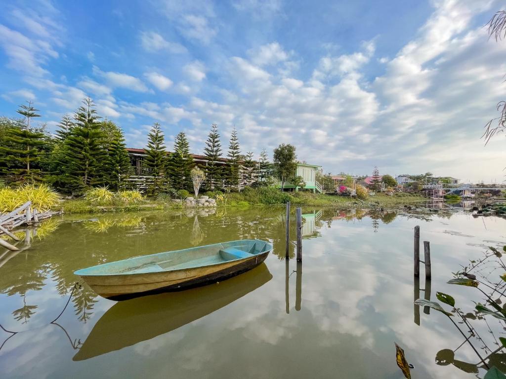 a boat sitting in the water on a lake at บ้านเขาค้อริมธาร in Ban Non Na Yao