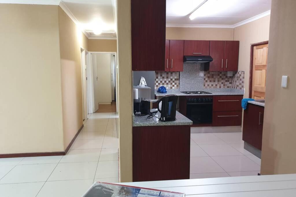a kitchen with brown cabinets and a counter top at Holiday Home in Port Elizabeth