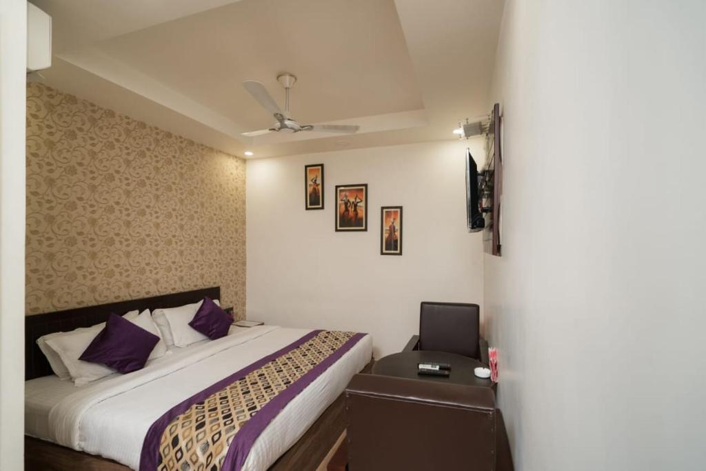 a bedroom with a bed and a desk with a laptop at HOTEL R R PALACE in Gorakhpur