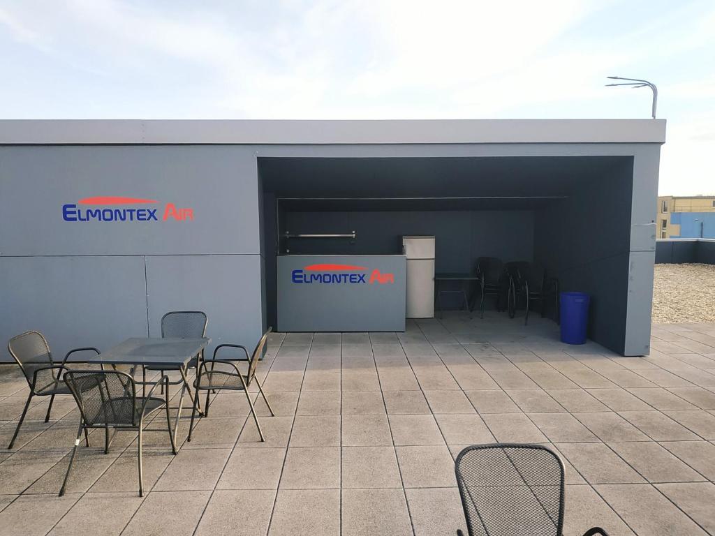 a building with a table and chairs in front of it at Elmontex Air in Mošnov